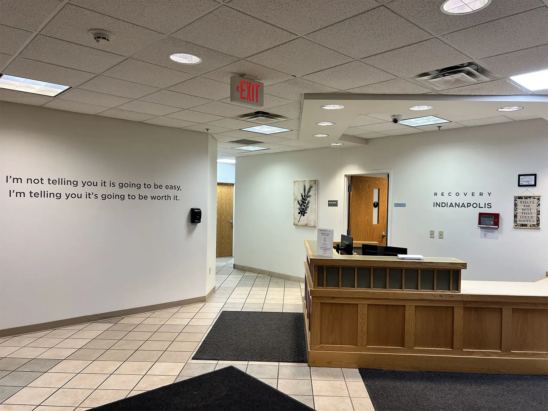 The reception area at Jasper Grove. Lettering on the wall reads: I'm not telling you it is going to be easy, I'm telling you it's going to be worth it.