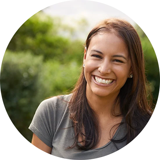 A woman smiles at the camera while standing outside. She is enjoying life after addiction treatment at Jasper Grove Recovery.