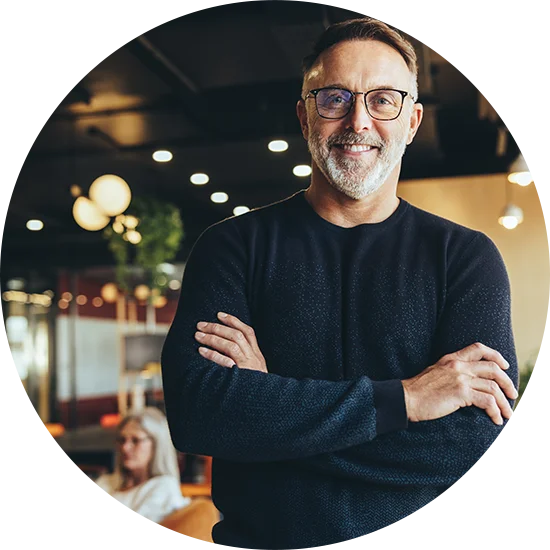 A man smiles with arms folded across his chest, looking directly at the camera. He's enjoying life after addiction treatment at Jasper Grove Recovery.