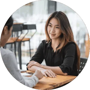 A young woman sits across from a therapist while participating in a therapy program at Jasper Grove Recovery.