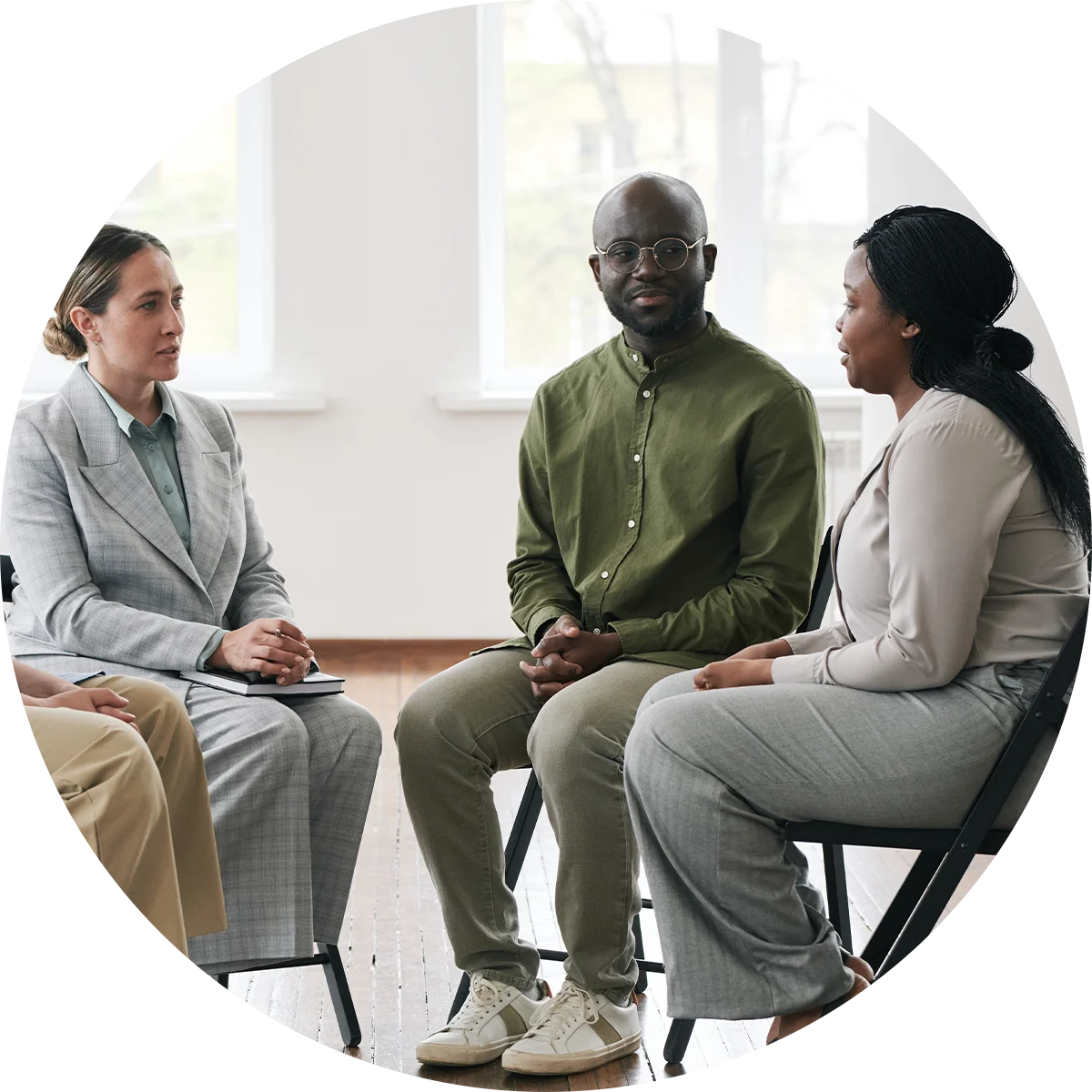 A young man and woman speak with a therapist while participating in a therapy program at Jasper Grove Recovery.