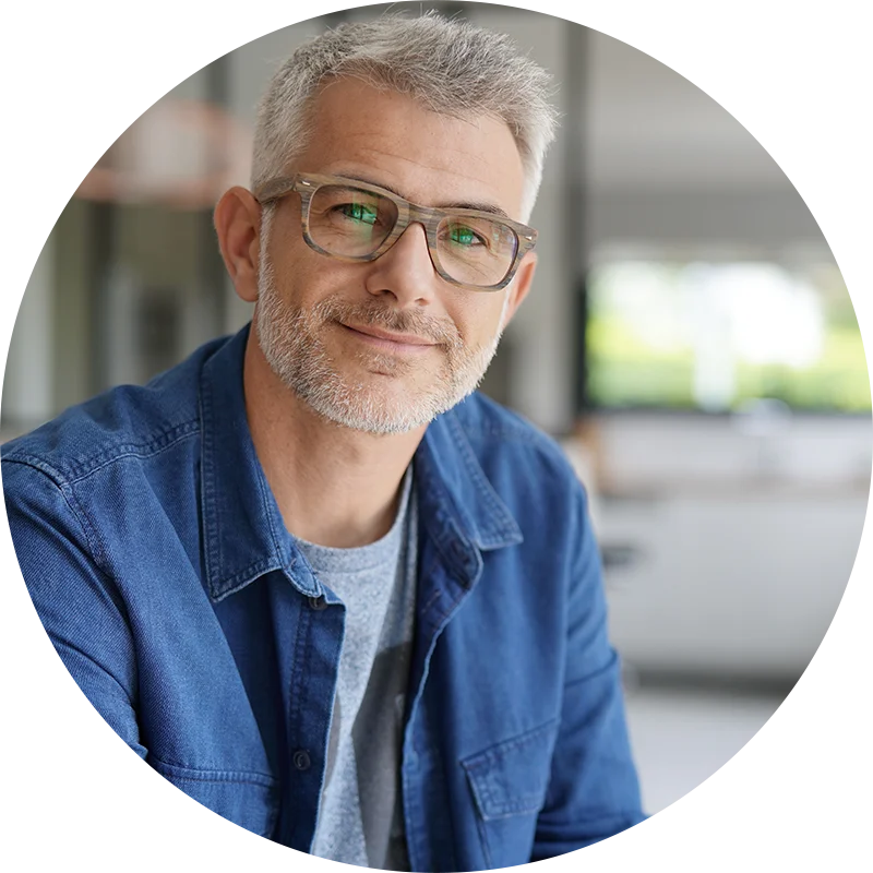 A man in glasses smiles at the camera. He is enjoying his participation in therapy at Jasper Grove Recovery.