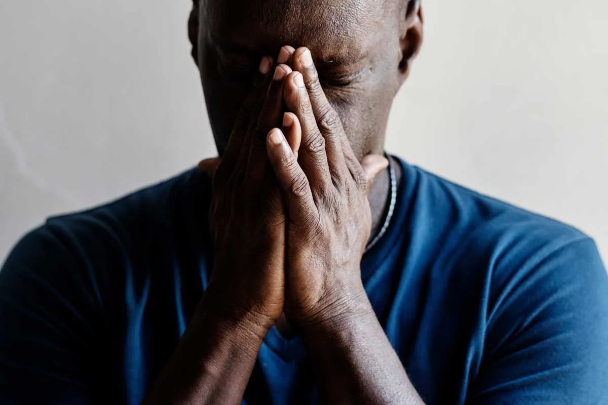 man with head in hands wonders about the connection between anxiety and addiction